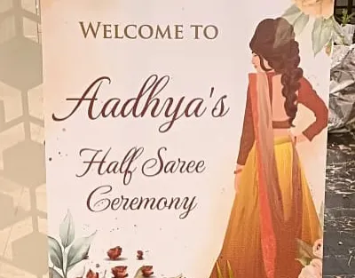 A personalized welcome sign for a Half Saree Ceremony, featuring a custom illustration to celebrate the young woman's milestone.