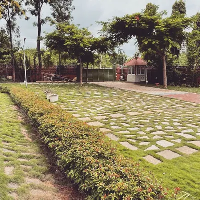 For this large farmhouse property, we designed a sprawling driveway using stone pavers set in a checkerboard pattern with grass. This approach creates a durable surface for vehicles while maintaining a green, permeable landscape.
