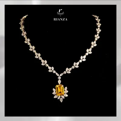 This exquisite necklace features a magnificent 25-carat yellow sapphire as its centerpiece. The gemstone is beautifully complemented by a delicate setting of marquise and round diamonds, designed to make the wearer shine.