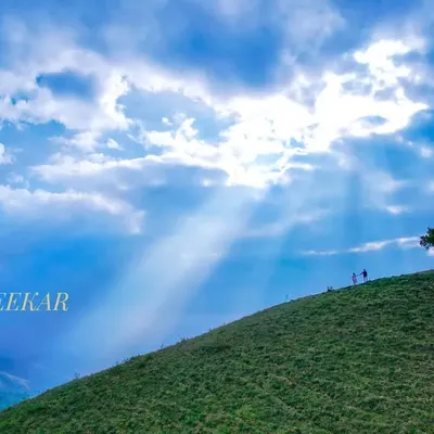 An epic drone shot of a couple on a Chikmaglur hilltop, dwarfed by the majestic landscape and heavenly sun rays. This is the kind of grand, scenic storytelling I love to create for pre-wedding films.