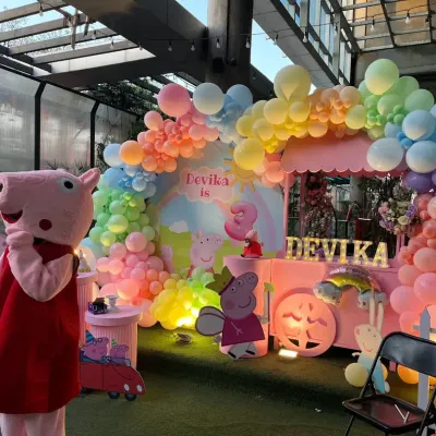 A full view of our Peppa Pig themed party setup. We created a vibrant scene with a pastel rainbow balloon arch, character cutouts, and a custom-designed backdrop for the birthday girl, Devika.