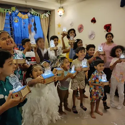 Look at these proud inventors! In our workshops, every child gets to build and take home their own creation, like these amazing custom light-up lamps. It's a glowing reminder of what they can achieve.