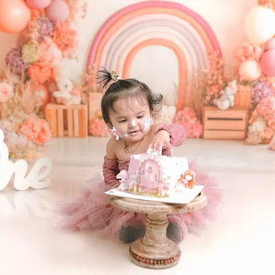 A little one curiously digs into her first birthday cake. This pastel rainbow themed shoot is one of my most popular, creating a soft and dreamy atmosphere.