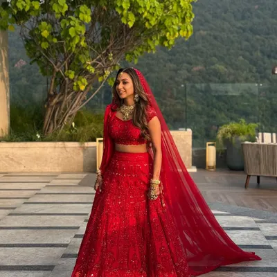 A full-length view of this stunning bride in her monochrome red lehenga at the Hyatt Regency Dehradun. The makeup was designed to be radiant and long-lasting, ensuring she looked perfect from her grand entrance to the final moments of the ceremony.