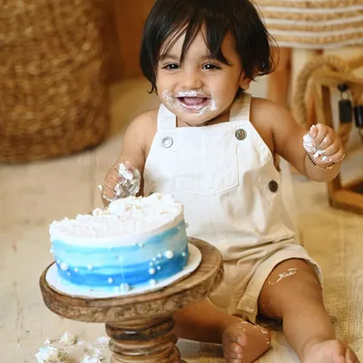 The perfect shot of a baby boy's joyful and messy cake smash. Milestone sessions like this are a fantastic way to celebrate a first birthday.