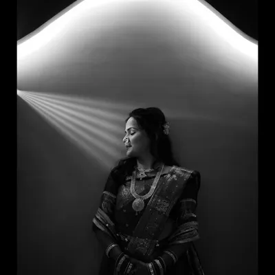 A beautiful black and white portrait using creative lighting. The bride is bathed in a soft, curved light from above, creating a serene and almost angelic image.