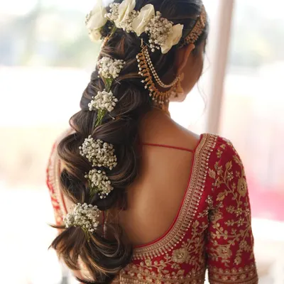 A bridal hairstyle should be a work of art. Here, I've created an intricate floral braid for a Pahadi bride, weaving in fresh flowers to create a unique and stunning look from every angle.