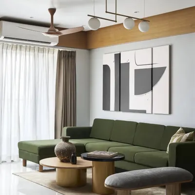 This wide view of the living room shows the L-shaped emerald green sofa, which adds a pop of natural color to the neutral palette. The space is designed for comfort and conversation, with a focus on natural textures.