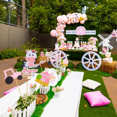 An overview of our pink barnyard party, designed for a second birthday. The setup includes a themed dessert table, a kid-friendly seating area with custom centerpieces, and charming farm animal cutouts.