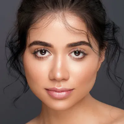 A classic headshot with a focus on clean, luminous skin and a gentle expression. The lighting is soft and even, creating a timeless portrait that is perfect for a model's portfolio.