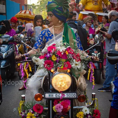A striking image from the Gudi Padwa parade in Girgaon, Mumbai, featuring a woman in traditional Maharashtrian attire on a motorcycle heavily decorated with flowers.