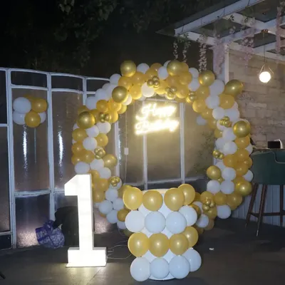 The complete setup for a first birthday party, featuring a balloon arch and a light-up number "1". We capture the beautiful decor you've planned.