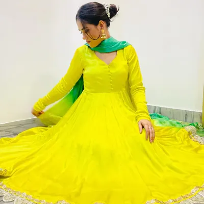 A full view of the lemonade yellow Anarkali with its flowing skirt and delicate lace hem. This outfit is crafted from a lightweight fabric, making it ideal for daytime functions and dancing.