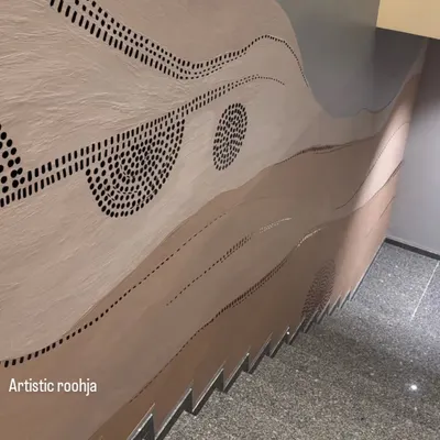 The final look of the abstract staircase mural, featuring earthy tones, flowing waves, and dotted patterns. The integrated lighting highlights the texture and form of the artwork.