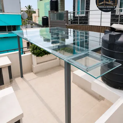 The final result of a sleek terrace transformation. This toughened glass pergola provides complete rain protection while keeping the space bright and open, showcasing a modern and minimalist aesthetic.