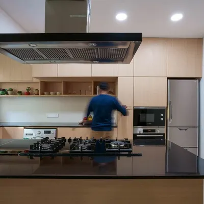 For this kitchen remodel, we focused on creating a highly functional layout tailored to the family's specific needs. The design features an island with a cooktop, ample counter space, and seamless integration of appliances within light wood cabinetry.