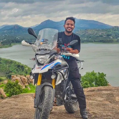 A rider and his BMW G310GS adventure bike posing against the backdrop of a beautiful lake. We welcome riders of all types of motorcycles, from adventure tourers to sportbikes.