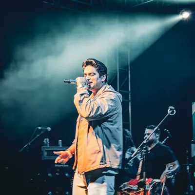 This edited shot of Amit Prakash Mishra focuses on creating a specific mood with color grading, capturing an intense moment of his performance under a single spotlight.