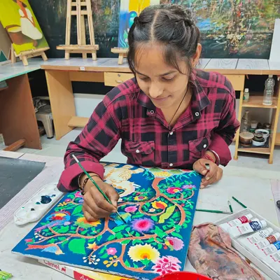 A student painting a detailed design on a ceramic piece. Our classes combine both sculpting and painting techniques to create finished ceramic artworks.