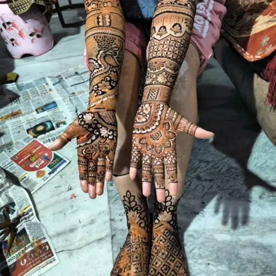 A complete bridal mehendi package includes stunning designs for the feet as well. This design perfectly matches the intricate peacock and jaali pattern on the hands.