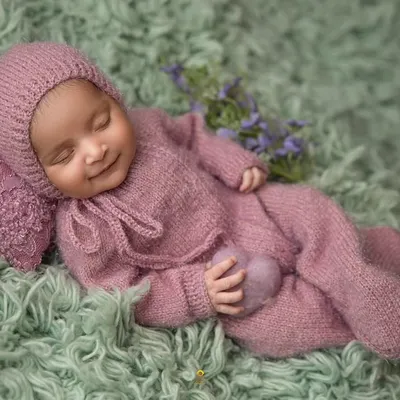 A perfect sleepy smile from a baby dressed in a cozy, knitted lavender outfit. This image embodies the peaceful and gentle nature of my newborn sessions.