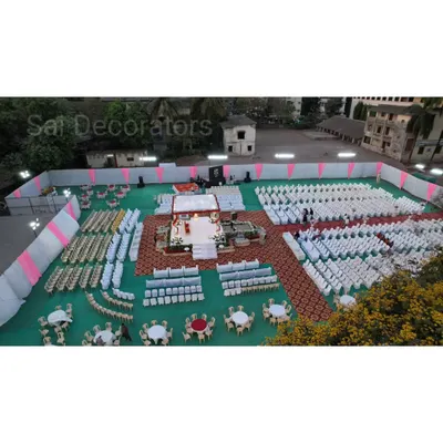 A high-angle view of an engagement ceremony setup on a large ground. This shows the organized seating arrangement for guests and the central mandap where the main ceremony takes place.