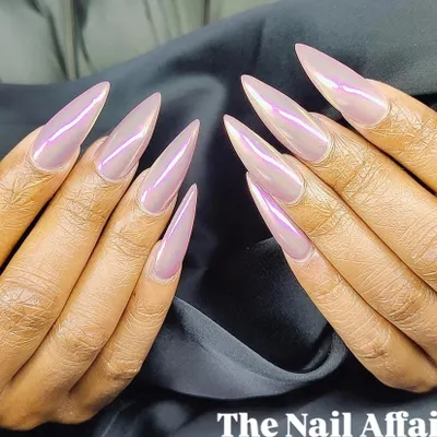 A dramatic set of extra-long stiletto nails with an iridescent pink "unicorn" chrome finish that shifts in the light.