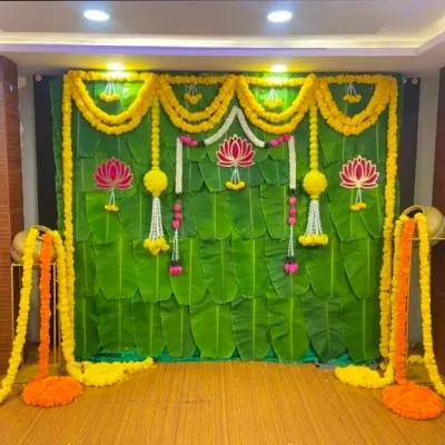 A classic backdrop made entirely of fresh banana leaves, adorned with marigold garlands and lotus flower cutouts. This is perfect for traditional poojas and ceremonies.