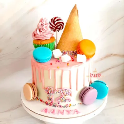 I absolutely loved creating this Candyland theme cake for Aanya's 12th birthday. It’s a buttercream drip cake decorated with colorful macarons, a mini cupcake, a lollipop, and an ice cream cone for that extra touch of fun. This is a perfect example of how I create a stunning centerpiece for a party, all without using fondant.