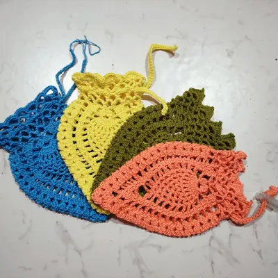 A collection of my handmade pineapple pouches in different colors. The lacy pattern is lightweight, and the drawstring closure keeps small items secure.