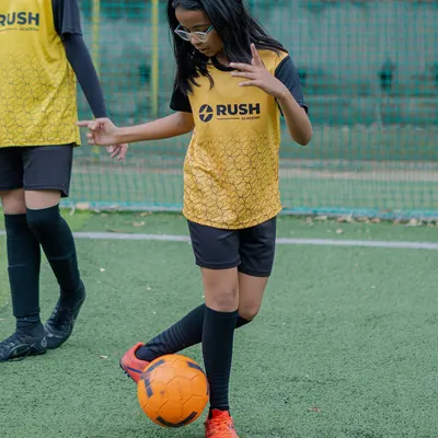 A young female player with excellent focus and ball control during a drill.