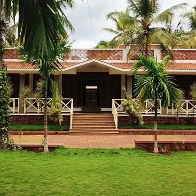 The 'Grid in the Grove' farmhouse was designed to be in complete harmony with its surroundings. The facade, with its terracotta roof and traditional details, is perfectly framed by the coconut and areca nut palms.