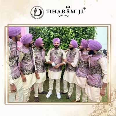 A groom and his groomsmen looking fantastic in coordinated outfits. They are wearing matching lilac and black patterned Nehru jackets over classic white kurtas, with matching lilac turbans. This is how you make the whole team look stylish.