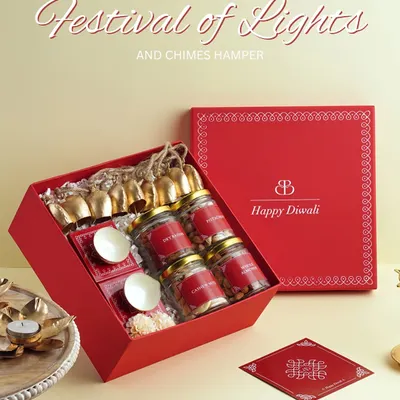 Our "Festival of Lights and Chimes" hamper was a bestseller for a reason. This vibrant red box is filled with jars of nuts, sweets, and a string of brass bells, making it a complete Diwali gift set.