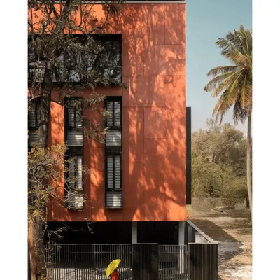 The building's east-facing orientation allowed us to strategically design openings that optimize natural light while minimizing heat gain. The monolithic red volume stands in striking contrast to the surrounding greenery.