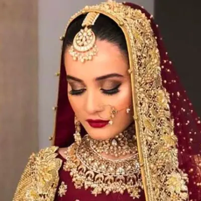 A classic bridal portrait showcasing a deep red lip and soft, smoky eyes. This timeless look is perfect for the traditional bride who wants to look regal and elegant.
