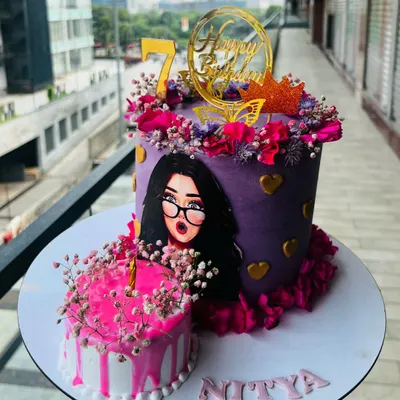 This custom tiered cake was designed for a 70th birthday celebration. It features a personalized caricature, a vibrant purple color scheme, and is paired with a smaller pink drip cake for a unique two-cake presentation.