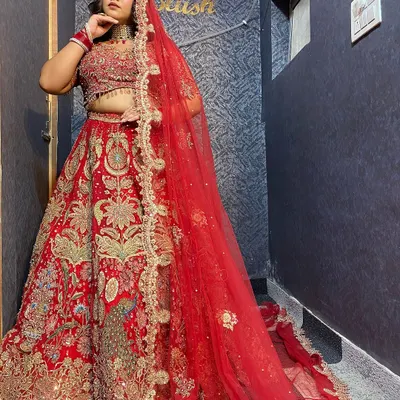 A classic red bridal lehenga with intricate gold embroidery. This is a timeless piece for the bride who wants a traditional and royal wedding day look.
