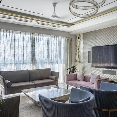 The living room of the 'Fifty Two' apartment in Lower Parel, designed for a well-travelled family. We aimed for a royal look that wasn't over-the-top, using a mix of plush fabrics, a statement chandelier, and a custom Patagonia marble coffee table.