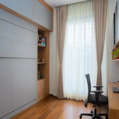A perfectly integrated workspace where functionality meets elegance. This home office features a Murphy bed hidden behind the grey panels, allowing the room to double as a guest space.