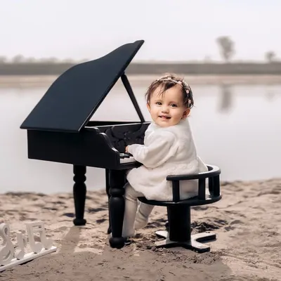 A tiny pianist creating her own melody by the water. This unique beachside setup with a miniature grand piano makes for truly magical and unforgettable photos.
