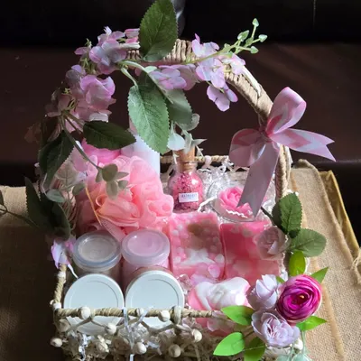 An elegant engagement hamper basket, beautifully decorated with pink flowers and filled with an assortment of my handmade pink-themed soaps, candles, and bath products.