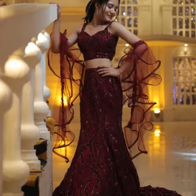 This client is ready for her sangeet in a stunning maroon sequin lehenga with dramatic ruffled sleeves. The makeup is kept glamorous with a focus on glowing skin and a matching lip.