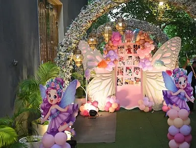 An enchanting entrance to a butterfly-themed party. We used a floral archway and life-size fairy cutouts to guide guests into a magical world.