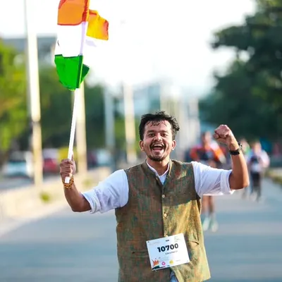 The joy and patriotism of a runner at our Freedom Run, celebrating with the Indian flag. This event is about more than just running; it's about community spirit.