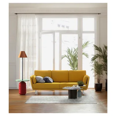 A piece from the 'Bernard and friends' collection in a bright, sunlit living room. The handcrafted wooden side table with an integrated lamp reflects our focus on natural materials and timeless, functional design.