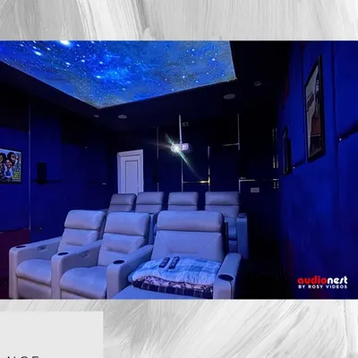 A view of our KEF T301 series home cinema installation. The starry ceiling, deep blue acoustic panels, and comfortable recliners create the perfect ambiance. This setup is designed for pure cinematic escapism.