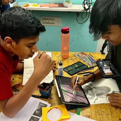 Collaboration and focus are key in the studio. Here, students work side by side, one sketching on paper and the other digitally, to master the fundamentals of drawing.