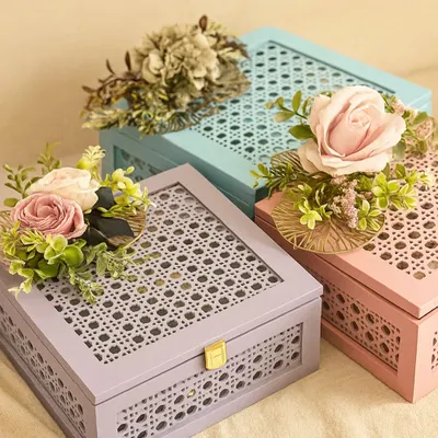 We love creating beautiful packaging that feels as special as the gift inside. This image showcases our pastel-colored, cane-detailed keepsake boxes, adorned with floral arrangements, ready to be customized for any occasion like Rakhi or a birthday.