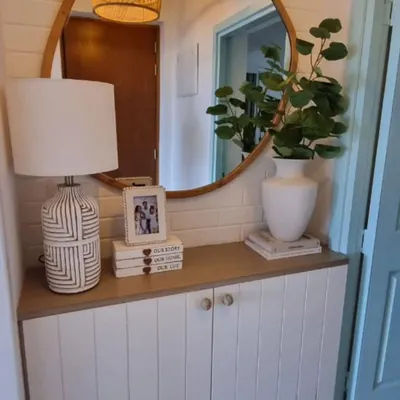 A perfect first impression. We executed this minimalist entryway to balance clean lines, warm wood, and a touch of green, creating a welcoming and stylish entrance.